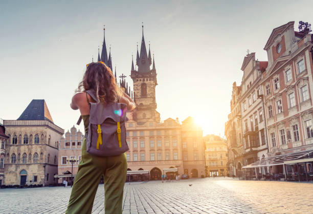 Young woman taking photo from the Tyn Church in Prague