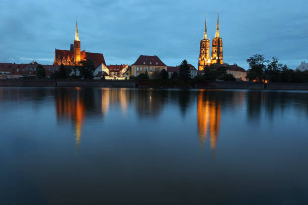 Cathedral of St. John the Baptist and Collegiate Church of the Holy Cross and St. Bartholomew and river Oder at night in Wroclaw, Poland.