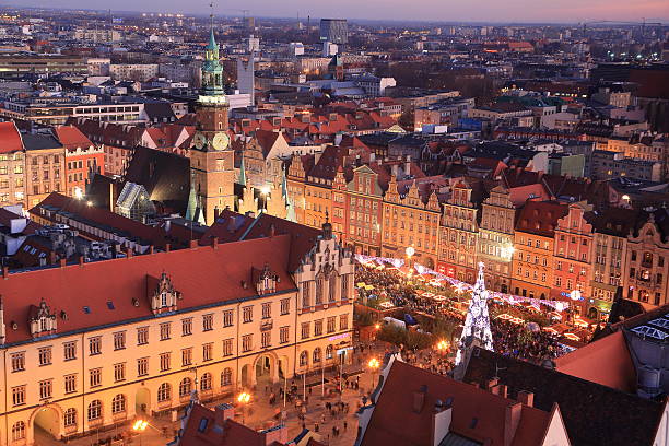 Illuminated Christmas Market in Wroclaw with the christmas tree in the center of the old market. Landscape of old city center. Wroclaw, Poland, Europe.
